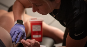 Provider working with a patient on strength and conditioning exercises at a sports physical therapy clinic in Decatur, GA